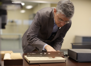 man leaning over a box of amulets