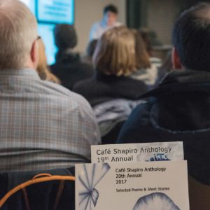 student performs creative work as guests listen