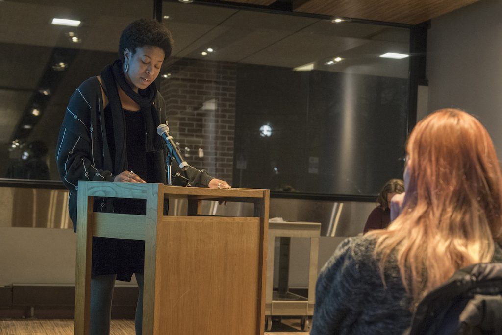 Photo of a woman standing at a podium in front of an audience