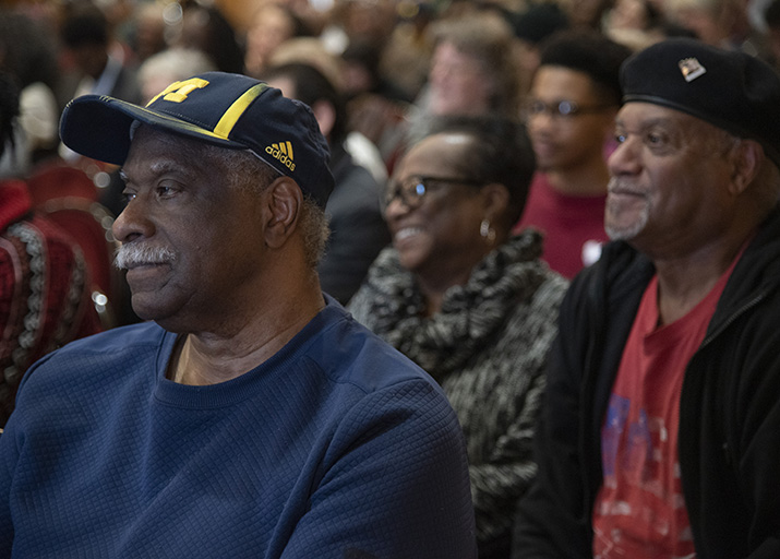 Photo of a man watching a lecture in a crowded audience