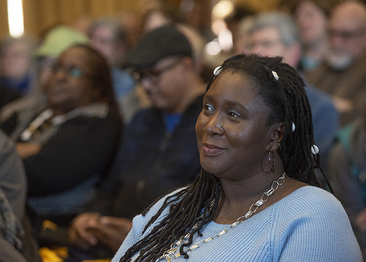 Photo of a woman watching a lecture in a crowded audience