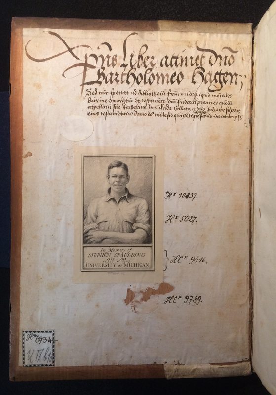 The inside cover of an old book, with handwritten text in Latin and a bookplate In Memory of Stephen Spaulding that includes his image