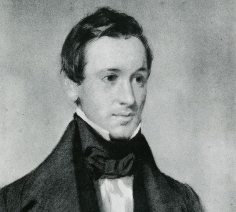 black and white photograph of a man from the shoulders up wearing a black cravat