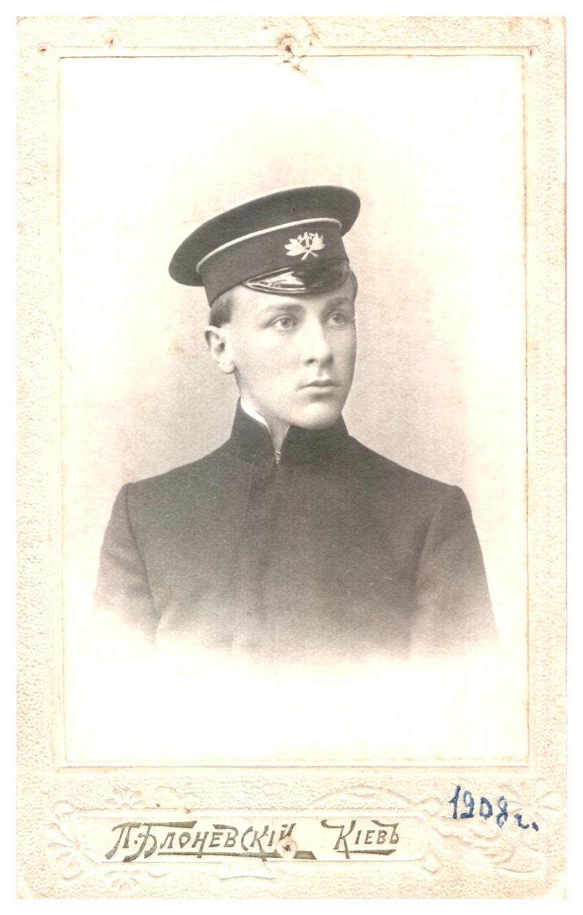 Black and white photo of a young man in uniform; handwritten text at the bottom includes a date, 1908, and text in Cyrillic